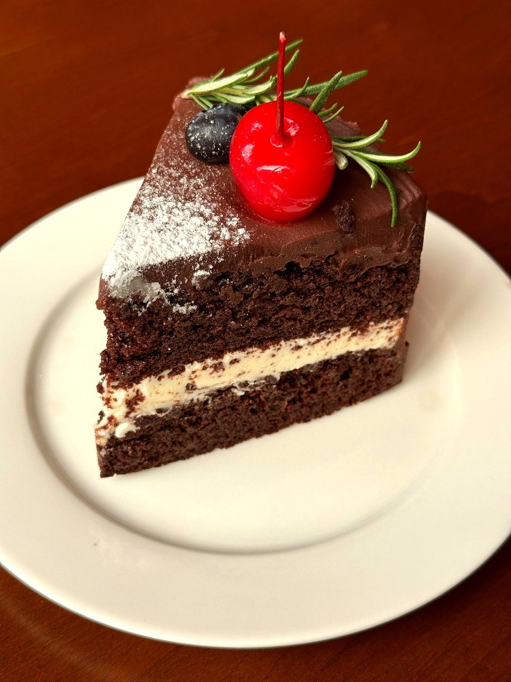 A slice of Matilda Cake showing its chocolate sponge and cream cheese buttercream layers